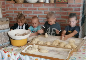 Czworo dzieci wyrabia ciasto na chleb