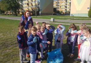 Dzieci z grupy "Słoneczka" pokazują swój worek po sprzątaniu trawnika