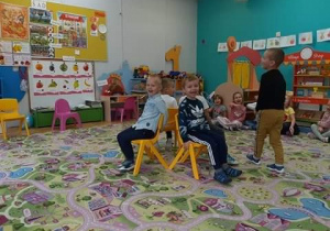 Chłopcy zajmują miejsca na krzesełkach podczas zabawy